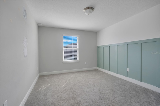 empty room featuring light colored carpet and a textured ceiling