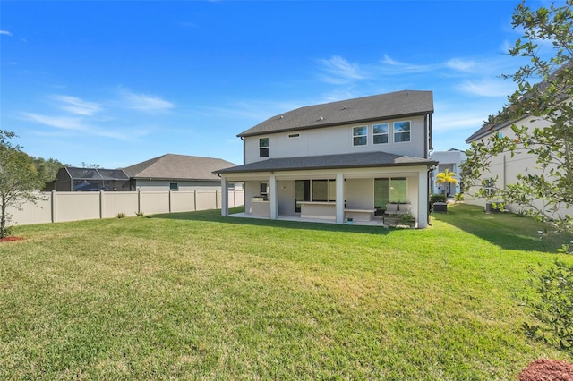 rear view of house featuring a yard and a patio