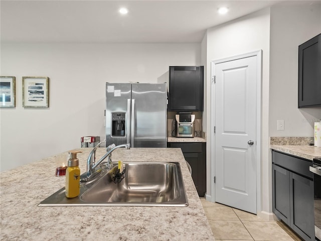 kitchen with stainless steel refrigerator with ice dispenser, sink, and light tile patterned floors