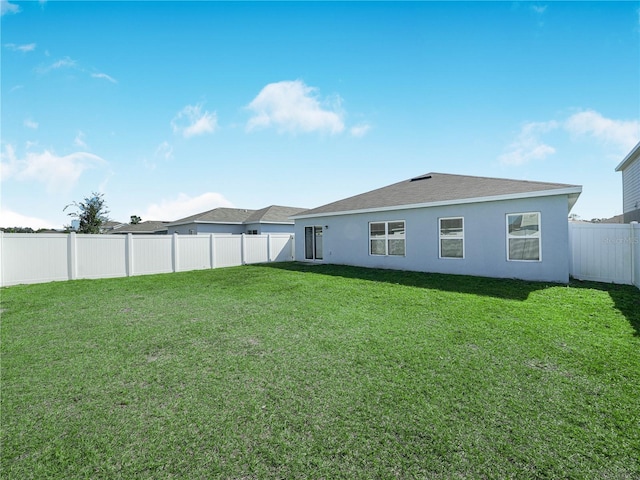 rear view of property featuring a yard