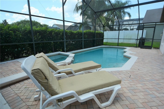 view of swimming pool featuring an in ground hot tub, a lanai, and a patio area