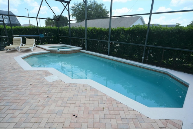 view of swimming pool with an in ground hot tub, a lanai, and a patio area