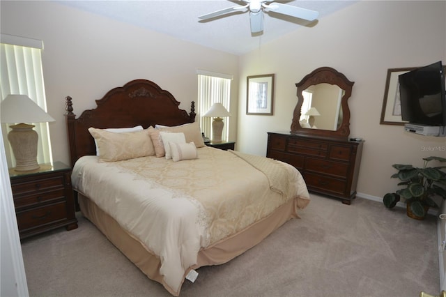 bedroom featuring vaulted ceiling, light colored carpet, and ceiling fan