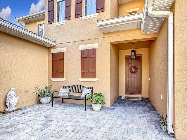 view of exterior entry featuring a patio area