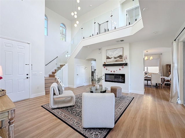 living room with light hardwood / wood-style flooring and a high ceiling