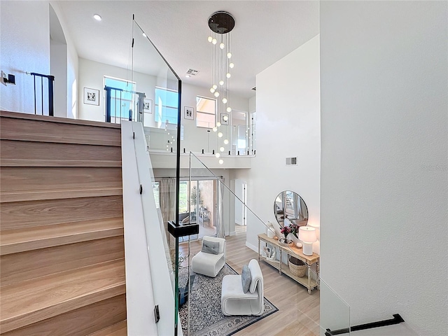 stairway featuring hardwood / wood-style floors and a high ceiling