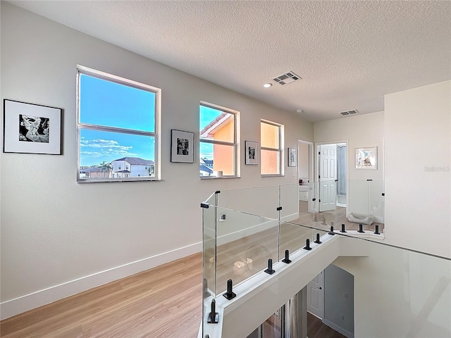 hallway featuring hardwood / wood-style flooring and a textured ceiling