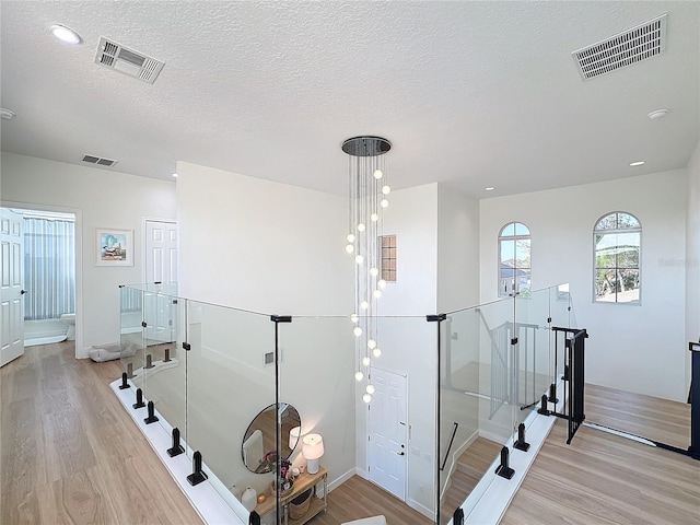 staircase featuring hardwood / wood-style floors and a textured ceiling