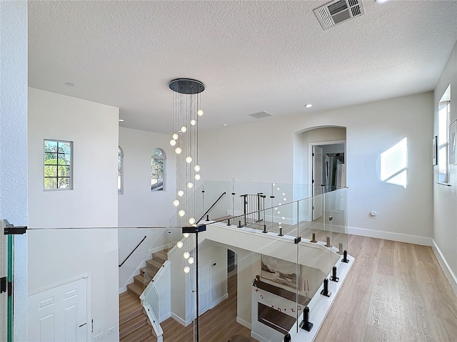 stairway with hardwood / wood-style flooring and a textured ceiling