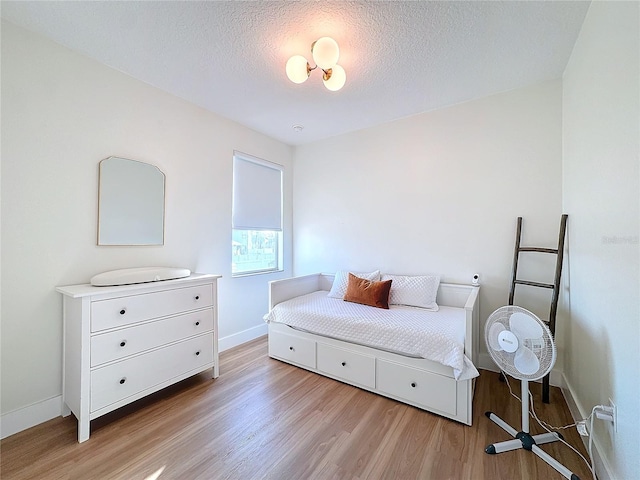 bedroom with a textured ceiling and light wood-type flooring