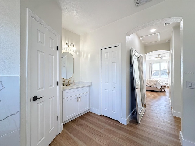 bathroom with vanity, wood-type flooring, and a textured ceiling