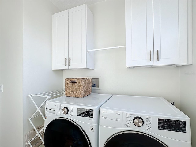 laundry room featuring cabinets and washing machine and clothes dryer