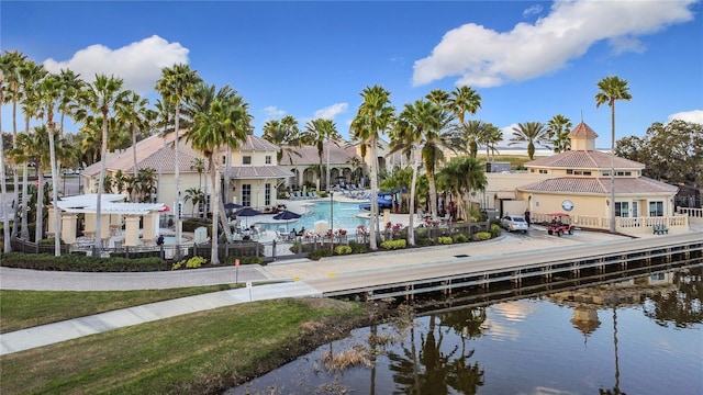 view of dock with a water view and a community pool