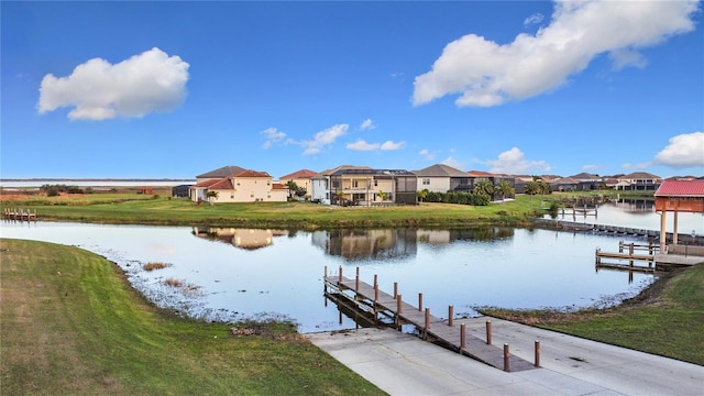 dock area with a lawn and a water view