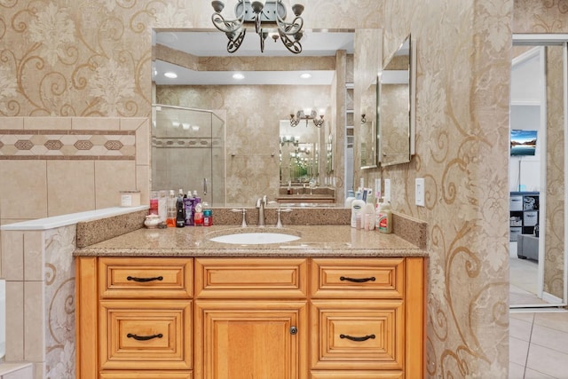 bathroom with vanity, a shower with shower door, tile patterned flooring, and tile walls