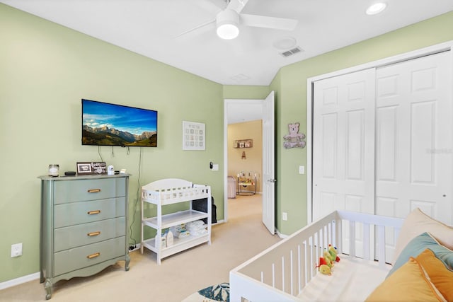 carpeted bedroom with ceiling fan and a closet