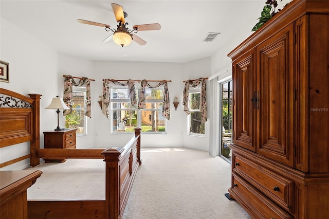 carpeted bedroom with multiple windows, access to exterior, and ceiling fan