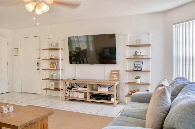 tiled living room featuring ceiling fan, a wealth of natural light, and a textured ceiling