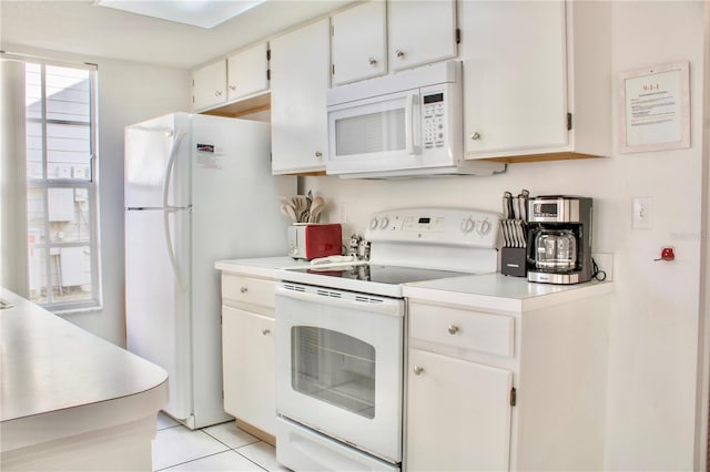 kitchen with light tile patterned floors, white appliances, and white cabinets