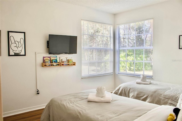 bedroom with dark hardwood / wood-style flooring and a textured ceiling