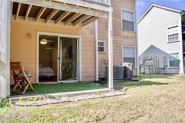 rear view of house featuring central AC unit and a lawn