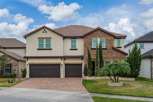 mediterranean / spanish-style house featuring a garage and a front yard