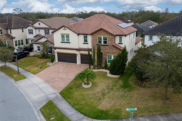 mediterranean / spanish-style house featuring a garage and a front lawn