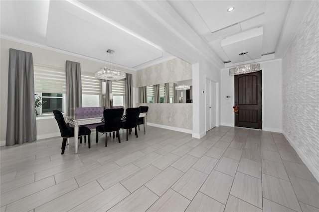 dining area with a notable chandelier, a tray ceiling, and ornamental molding