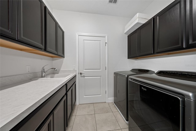 laundry room featuring sink, cabinets, washing machine and clothes dryer, and light tile patterned flooring