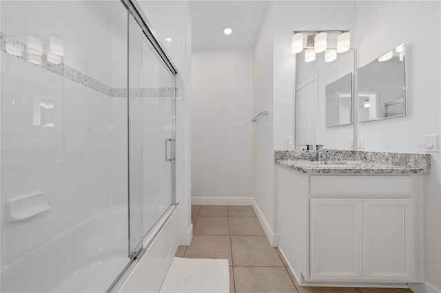 bathroom with tile patterned flooring, vanity, and combined bath / shower with glass door