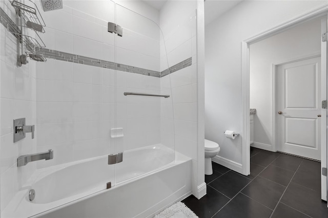 bathroom featuring tiled shower / bath, tile patterned floors, and toilet