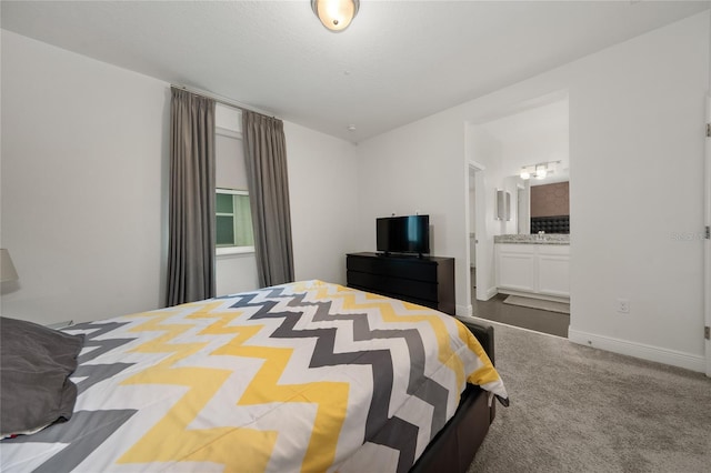 bedroom featuring ensuite bath and carpet floors