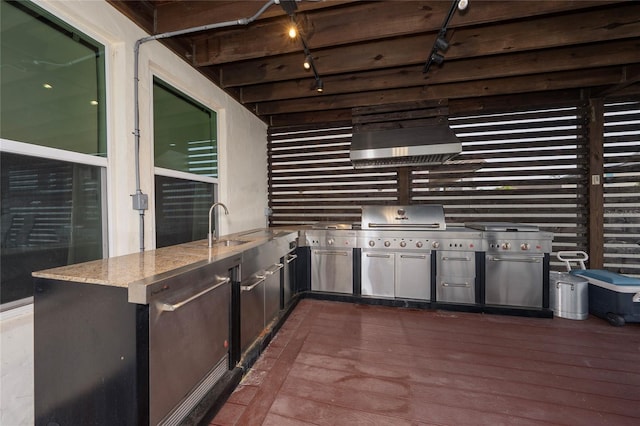 kitchen with premium range hood, sink, light stone counters, dark hardwood / wood-style floors, and kitchen peninsula