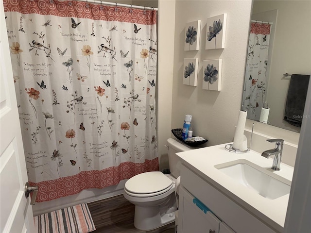 full bathroom featuring hardwood / wood-style flooring, vanity, shower / bath combination with curtain, and toilet