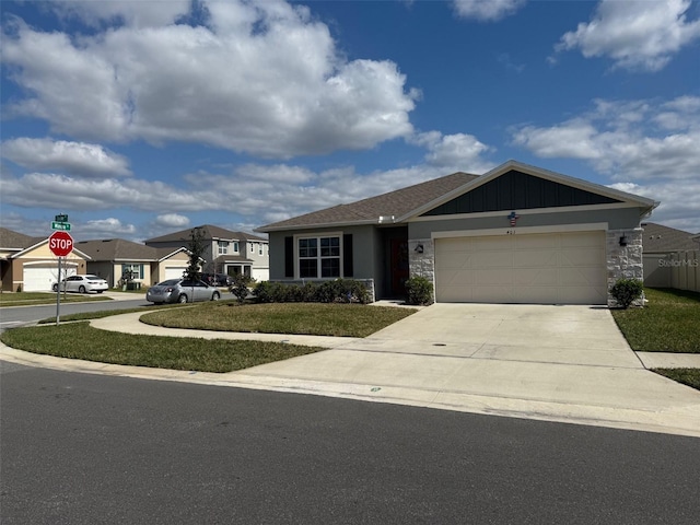 view of front of house with concrete driveway, board and batten siding, a garage, a residential view, and stone siding