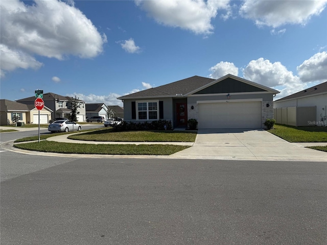 view of front of property featuring a garage, driveway, a front lawn, and fence