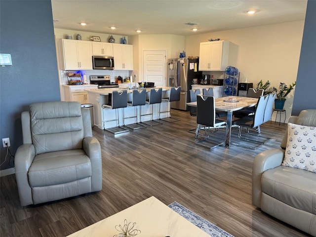 living room with recessed lighting and dark wood-style flooring