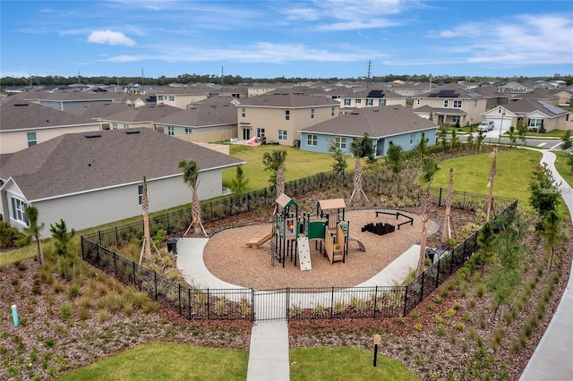 communal playground with a residential view, fence, and a yard