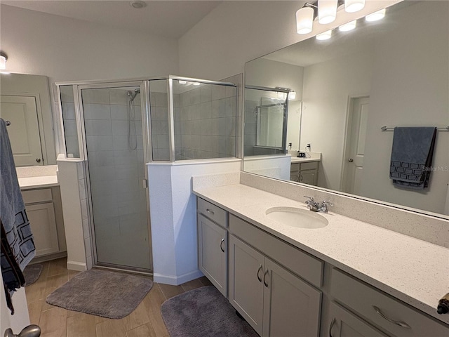 bathroom with vanity and a shower with door