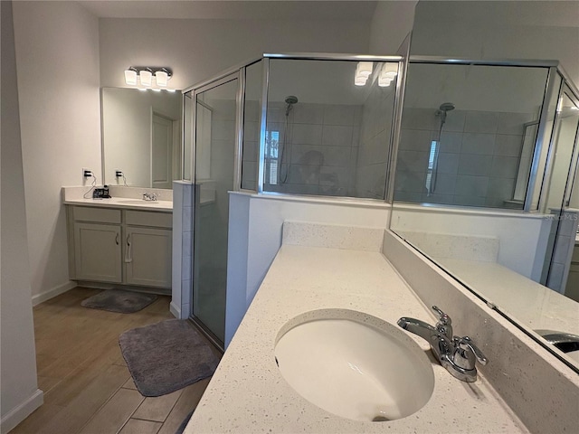 bathroom with vanity, hardwood / wood-style flooring, and walk in shower