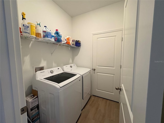 washroom with hardwood / wood-style flooring and washer and dryer