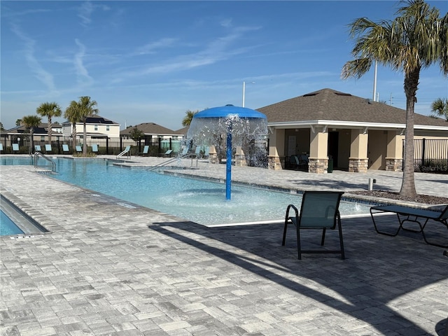 view of swimming pool with pool water feature and a patio area