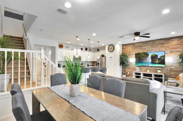 dining room with wooden walls and ceiling fan