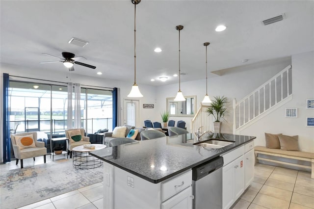 kitchen with white cabinetry, stainless steel dishwasher, sink, and a center island with sink