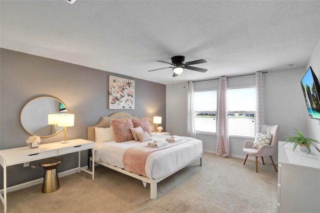 carpeted bedroom featuring a textured ceiling and ceiling fan