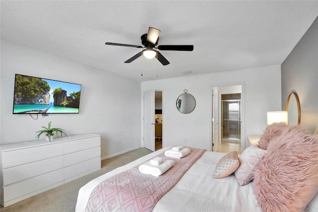 bedroom with ensuite bathroom, light carpet, and ceiling fan