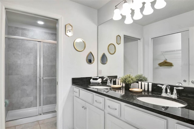 bathroom with a shower with door, vanity, and tile patterned flooring