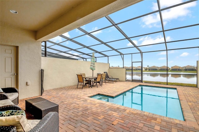 view of swimming pool with a water view, a patio area, and glass enclosure