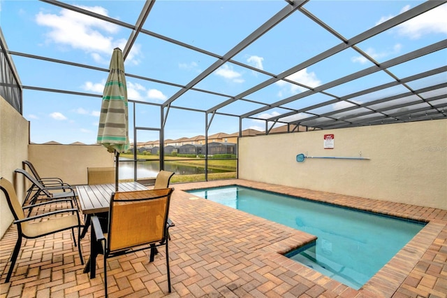 view of swimming pool featuring a water view, a lanai, and a patio area