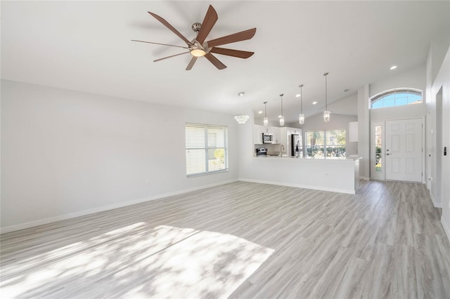 unfurnished living room with high vaulted ceiling, ceiling fan, and light wood-type flooring